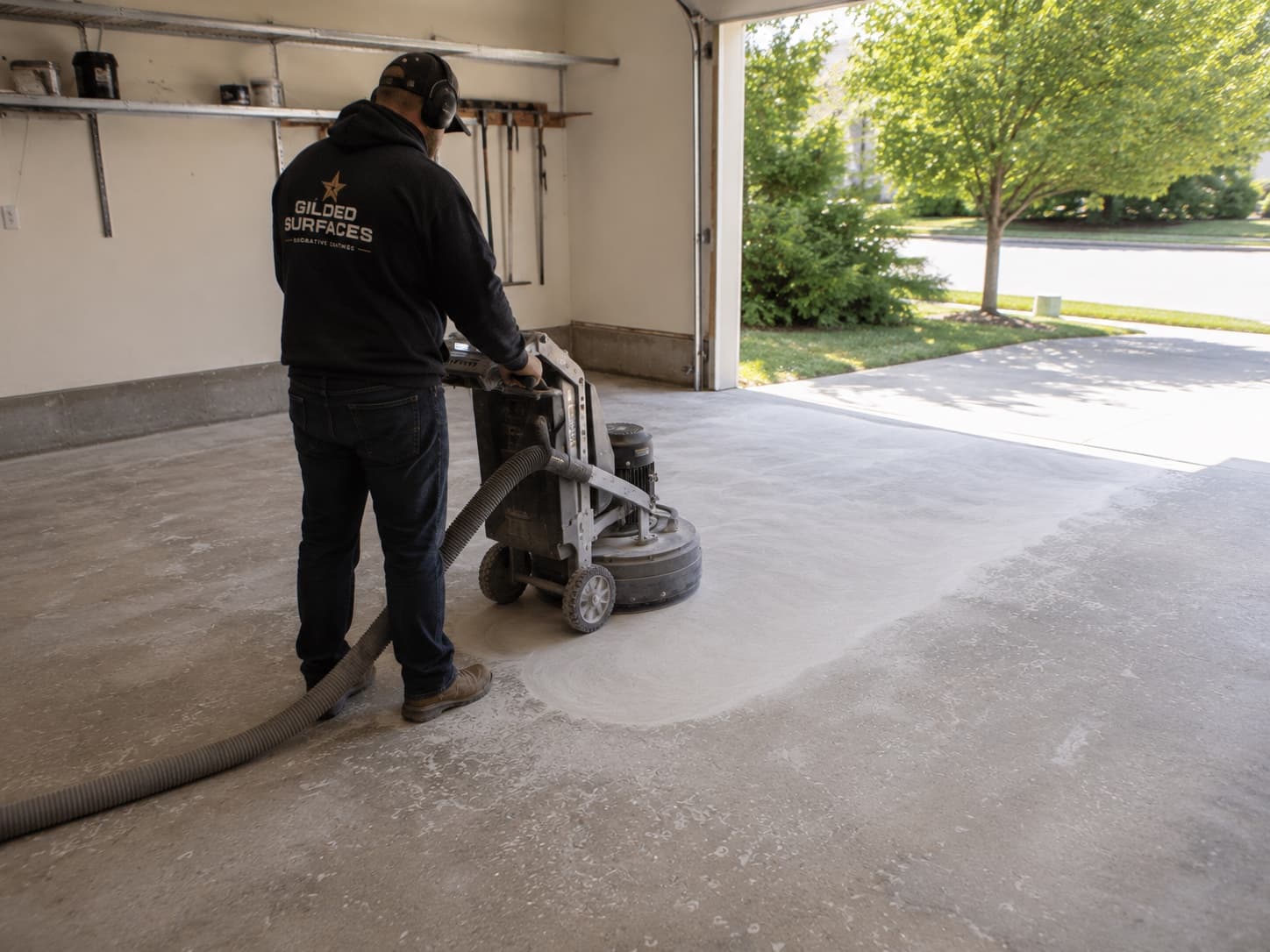 Crew member guiding a diamond grinding machine with dust extraction